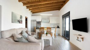 Un soggiorno moderno con un divano, un tavolino da caffè e una TV a parete.