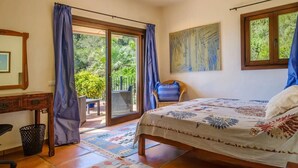 Une chambre à coucher avec un lit, un bureau, une chaise et une vue sur l’extérieur.