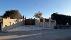 A gated entrance with stone walls and a wooden gate, leading to a driveway. - Rural Charm with Pool – Villa Damián 12 (Alcúdia)
