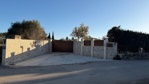 A gated entrance with stone walls and a wooden gate, leading to a driveway. - Rural Charm with Pool – Villa Damián 12 (Alcúdia)
