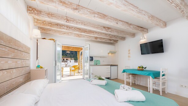 A bedroom with a bed, a desk, a chair, a television, and a view of the outside. - Apartment Close to the Beach with Pool Access, Private Terrace, Air Conditioning and Wi-Fi (Canyamel)