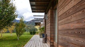 A wooden deck leading to a modern building with a mountain backdrop. - In the hills with panoramic views – Apartment GeoResort A4 (Tremosine)