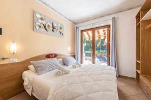 Camera d'albergo con un letto, un'opera d'arte appesa al muro, un armadio e vista sull'esterno.