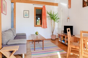 Un soggiorno accogliente con un divano, un tavolo di legno, una TV e una libreria.