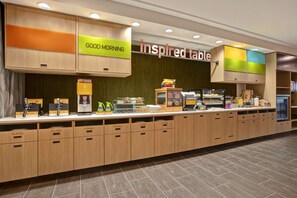 A breakfast bar with labeled cabinets for plates, utensils, and a sign that reads "GOOD MORNING inspired table".