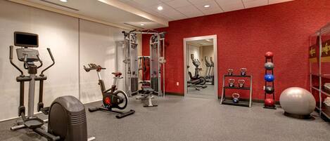 A gym with cardio machines, weightlifting equipment, and exercise balls.