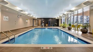 An indoor swimming pool with clear water, surrounded by tiled walls and a ceiling with recessed lighting. - Home2 Suites by Hilton Carmel Indianapolis (Carmel)
