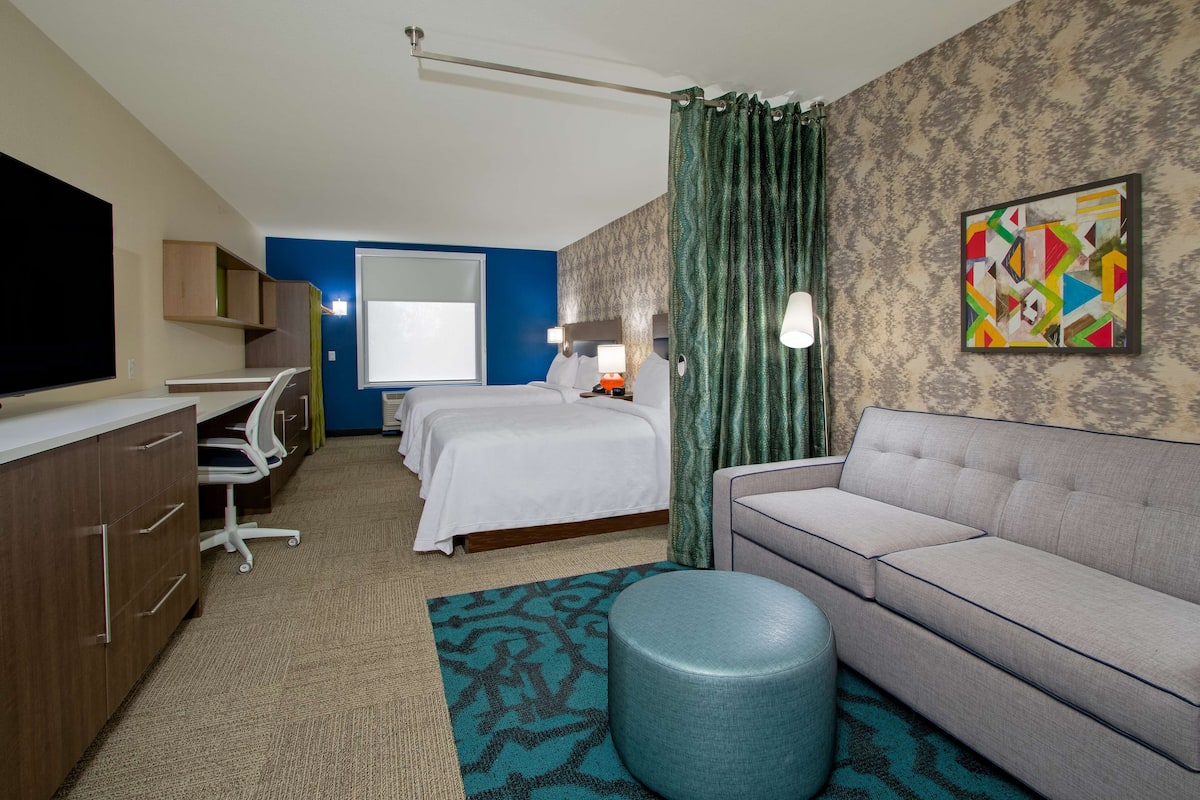 Een hotelkamer met een bed, een bank, een bureau en een televisie.