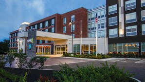 A modern hotel with a brick facade, large windows, and a welcoming entrance.