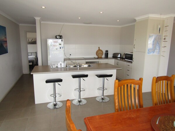 Enjoy cooking and dining in this functional kitchen with a central island, sink, and modern appliances.