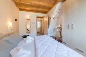 Un dormitorio con una cama grande, techo de madera, armario y espejo.