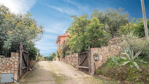 A rural pathway leading to a stone-walled building with a metal gate, surrounded by greenery and a clear sky. - Holiday Apartment "Runcina 2" with Sea View in Green Landscape (san teodoro)