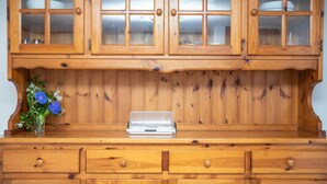 A wooden kitchen with a built-in microwave, wooden cabinets, and a vase with flowers on the countertop. - Holiday Apartment "Runcina 2" with Sea View in Green Landscape (san teodoro)