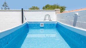 A rooftop swimming pool with a ladder, surrounded by white walls and a tiled roof. - Charming Home with Pool, Large Lawn, Patios & Wi-Fi; Parking Available, Pets Allowed (Conil de la frontera)