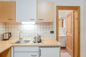 A kitchen with a sink, stove, and cabinets.