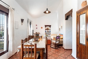 Un espace repas comprenant une table, des chaises et un luminaire suspendu.