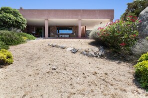 A modern building with a flat roof, a large window, and a stone facade.