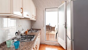 Une cuisine équipée d’une cuisinière à gaz, d’un évier et d’un réfrigérateur.