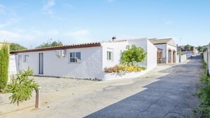 A quiet street with white buildings, a clear sky, and a paved road. - Comfortable Holiday Apartment "Loft Rural" with Terrace (El Soto)