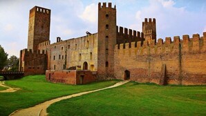 Un castillo histórico con un patio central, muros altos y dos torres destacadas.