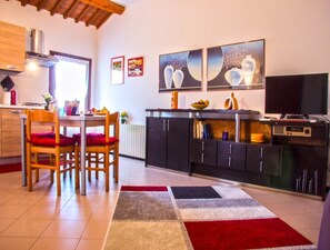 Eine moderne Küche mit Essbereich, ausgestattet mit einem Holztisch, Stühlen, einem schwarzen Schrank und einem Bild an der Wand.