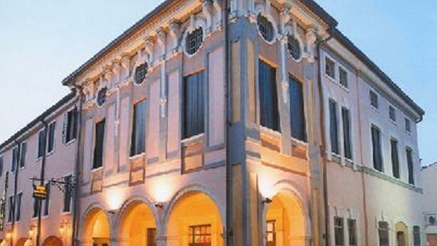 Un edificio clásico con ventanas arqueadas y una entrada central.