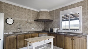 Une cuisine avec des meubles de rangement en bois, un évier, un four à micro-ondes et une fenêtre.