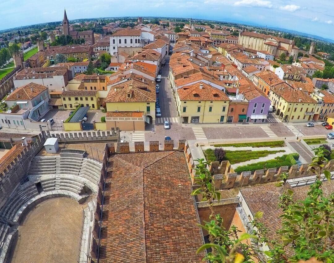 Eine Vogelperspektive einer historischen Stadt mit einem markanten Kirchengebäude, einem weitläufigen Platz und terrassenförmig angeordneten Häusern.