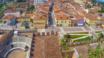 An aerial view of a historic town with a prominent church, a large open square, and terraced buildings.