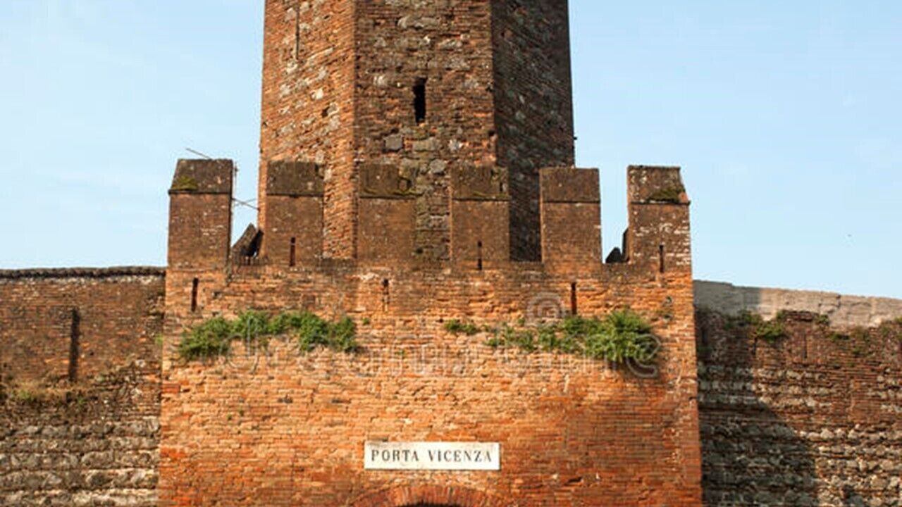 Een bakstenen toren met een bord waarop 'PORTA VICENZA' staat.
