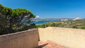 A coastal view with a clear sky, a tree, and a rocky landscape. - Quietly Situated Holiday Home with Sea View, Garden & Terrace (Arzachena)