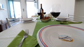 A dining table set with plates, glasses, and a fork on a green tablecloth.