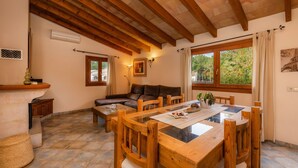 Un comedor con mesa y sillas de madera, un sofá y una chimenea.