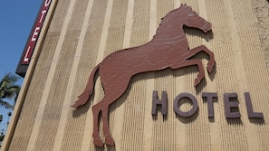 A hotel sign with a horse silhouette and the word 'HOTEL' on a textured wall.