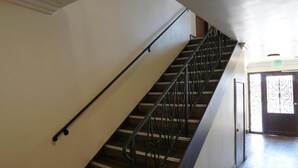 Una escalera con barandillas de metal que sube a un piso superior.