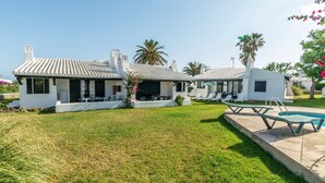 A modern villa with a swimming pool, outdoor seating, and a well-maintained lawn. - Beautiful Holiday Home in Residential Complex with Pool, Wi-Fi, Terrace and Lawn (Binisafua)
