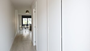 A narrow hallway with a dining area at the end, featuring a table and chairs. - Estudis Laura (Castell-Platja d'Aro)