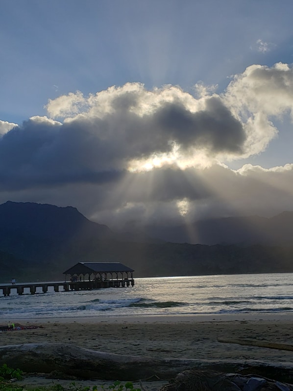 A pier extending into a body of water with mountains in the background.