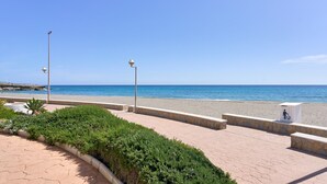 A paved walkway with benches, a trash bin, and street lamps. - Bright Apartment Estela Maris with Direct Beach Access (Nerja)