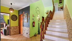 A staircase with wooden balusters, a wall clock, and a fire extinguisher. - Mediterranean Villa "Calipso" with Wi-Fi, Terrace and Pool (Albufeira)