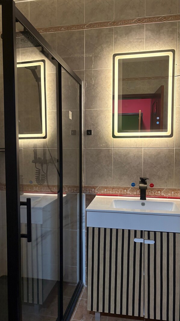 A modern bathroom with a glass shower enclosure, a vanity with a striped cabinet, and a mirror with illuminated edges. - Mediterranean Villa "Calipso" with Wi-Fi, Terrace and Pool (Albufeira)