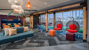 Un área de estar moderna con un sofá, sillones y una mecedora colgante.