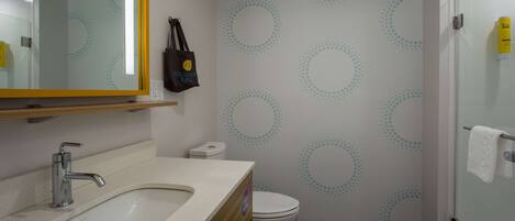 A modern bathroom with a sink, toilet, and shower.