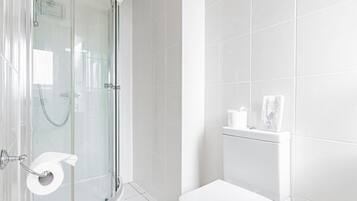 A modern bathroom with a glass shower enclosure, a toilet, and a towel rack.