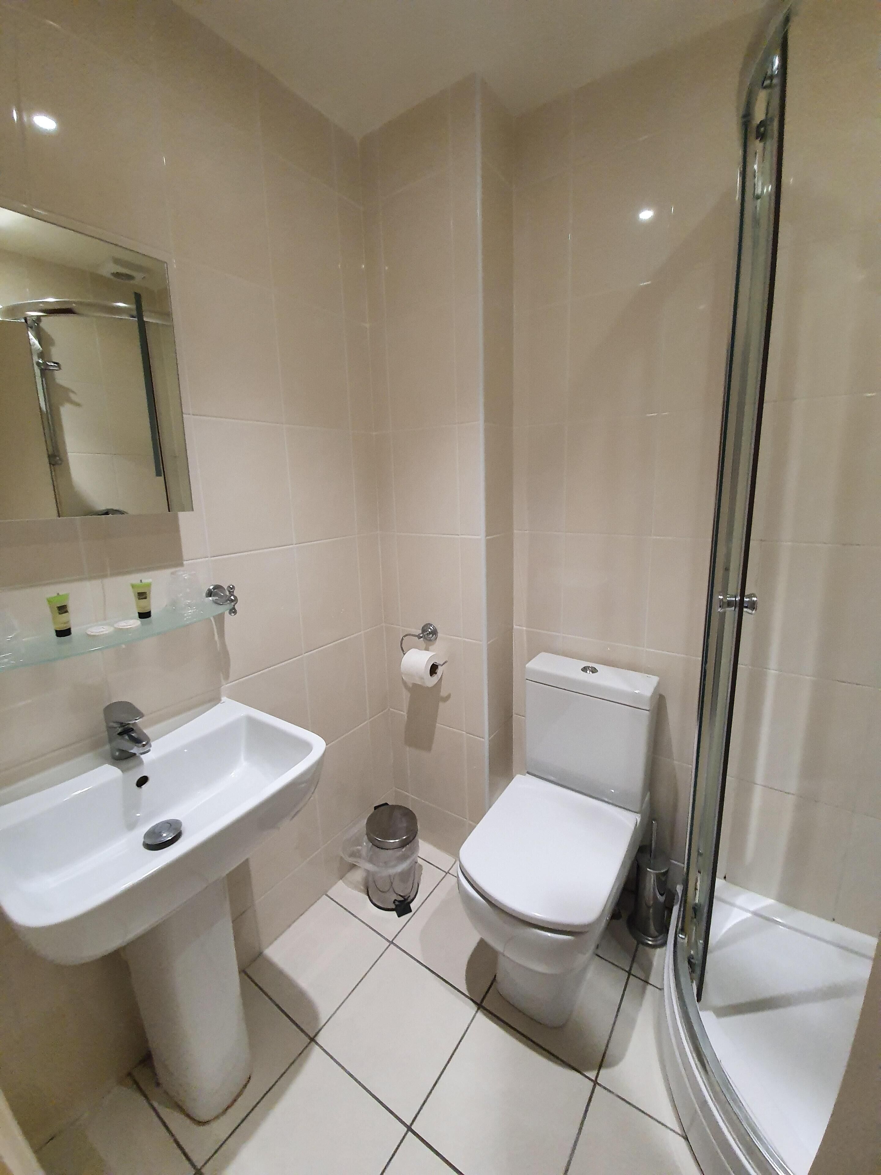 Une salle de bain équipée d’un lavabo, de toilettes et d’une douche à parois en verre.