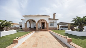 A house with a tiled patio, white walls, and a brick chimney. - Family Home "La Lobita 1" Short Drive from Beach with Pool, Terrace and Wi-Fi (Conil de la Frontera)