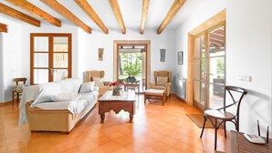 Un salón amplio con sofá, sillas, una mesa de centro y vistas a través de un ventanal.