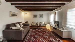 A living room with a sofa, two armchairs, a TV, and a patterned rug. - San Pantalon Luxury Penthouse R&R (Venecia)
