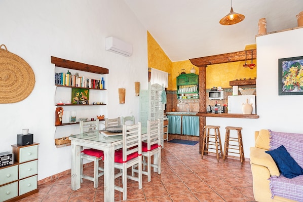 A cozy kitchen with a dining area, a bar, and a living room with a sofa.