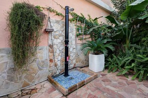A stone wall with a metal structure, possibly a water feature, and a potted plant. - Lelu' a Welcoming End-of-Terrace House with a Private Garden and Terrace (Villasimius)